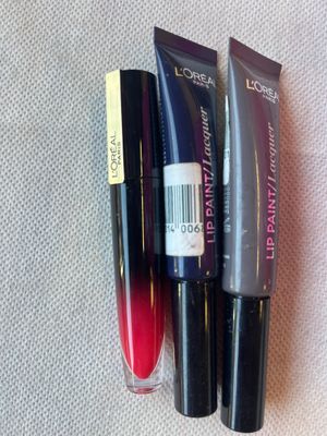 trois rouges à lèvres de teintes différentes sont posés sur une surface blanche