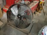 un ventilateur posé par terre dans une pièce