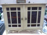 une armoire blanche avec des portes vitrées posée sur une table