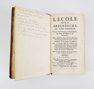 un livre ouvert avec une écriture dessus, posé sur une table