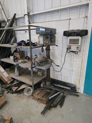une machine qui se trouve dans un garage, à côté d'un tas de bois