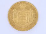 a gold coin on a white surface with a crown on it