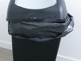a black trash can with a white bowl in it