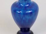 a blue vase that is sitting on a white surface