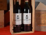 two bottles of wine in a wooden box on a table