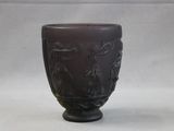 a brown vase with a design on it on a white surface