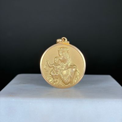 une image représentant une médaille d'or posée sur un socle blanc