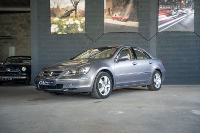 une voiture argentée garée dans un garage à côté d'une voiture noire
