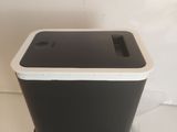 a black and white trash can sitting on a plastic bag
