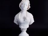 buste en marbre blanc représentant une femme avec une fleur dans les cheveux