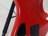a red guitar that is sitting on top of a tripod