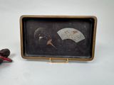 a small wooden box with a picture of a bird and a fan on it