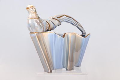 un vase en argent surmonté d'un oiseau