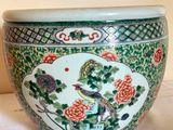 a green and white bowl with a bird and flowers on it
