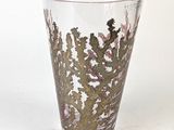 a glass vase with a cactus on it on a table