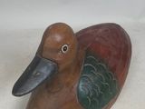 a small wooden duck that is sitting on a table
