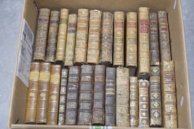 une boîte pleine de vieux livres posée sur le sol