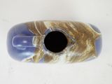 a blue and brown vase on a white table