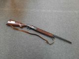 an old rifle with a wooden handle and a leather strap