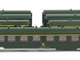 three green and yellow train cars sitting next to each other on a white surface