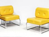 pair of yellow leather lounge chairs with chrome legs on a white background