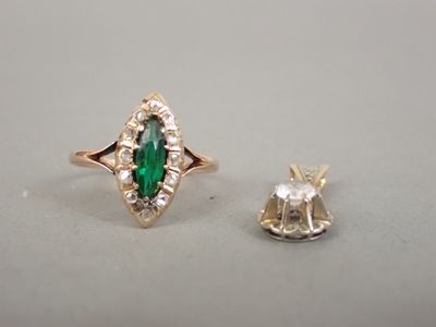 un gros plan d'une bague sertie d'une pierre verte et d'un diamant blanc