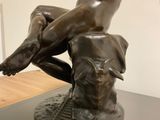 statue of a woman sitting on top of a table with a dog