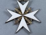 a white and gold star on a black and white medal