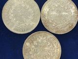three silver coins on a blue background