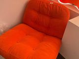 une chaise orange dans un coin de la pièce