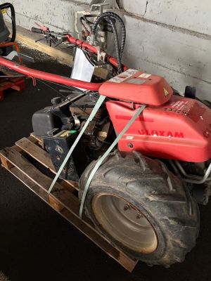 a small red tractor with a big tire on a pallet