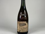 une vieille bouteille de vin posée sur une table, sur fond blanc