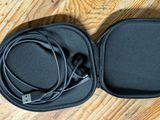 un casque audio dans son étui, posé sur un parquet