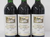 three bottles of red wine are lined up on a white surface