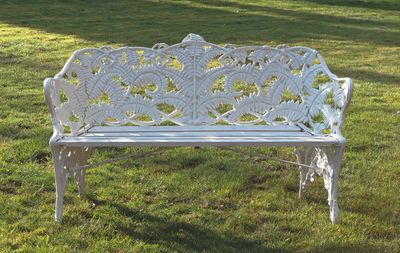 un banc blanc au milieu d'un champ herbeux