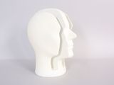a white mannequin head on a white table
