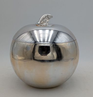 un récipient argenté brillant en forme de pomme, surmonté d'une feuille