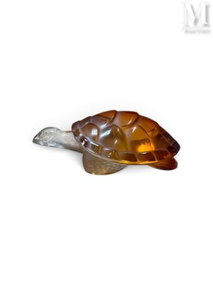 figurine de tortue en verre brun posée sur une surface blanche