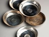 six bols plaqués argent posés sur une table avec un fond blanc