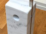 a white marble block with a metal pole on the floor