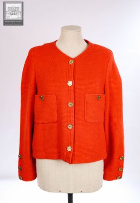 une veste orange sur un mannequin, avec des boutons