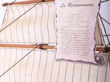 a wooden model of a sailboat with a sign on it