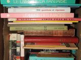 plusieurs livres empilés dans une boîte