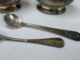 three silver spoons and two silver bowls on a table
