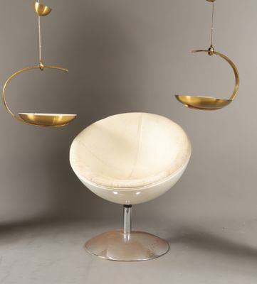 une chaise blanche et une assiette dorée suspendue au plafond