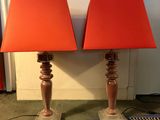 une paire de lampes orange avec des abat-jours rouges, posées sur un tapis