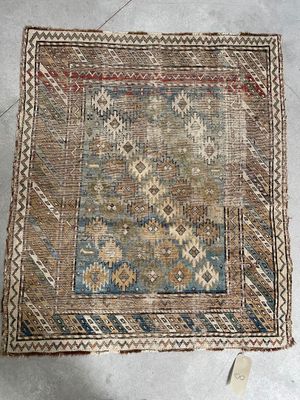 an old rug on the floor with a cat laying on it