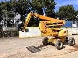 a yellow crane that is sitting in the dirt
