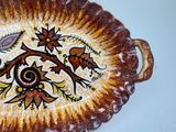 a brown and white plate with a floral design on it