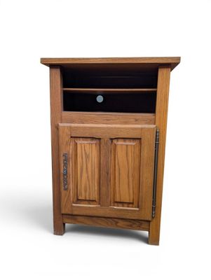un petit meuble en bois muni d'une porte et d'un tiroir